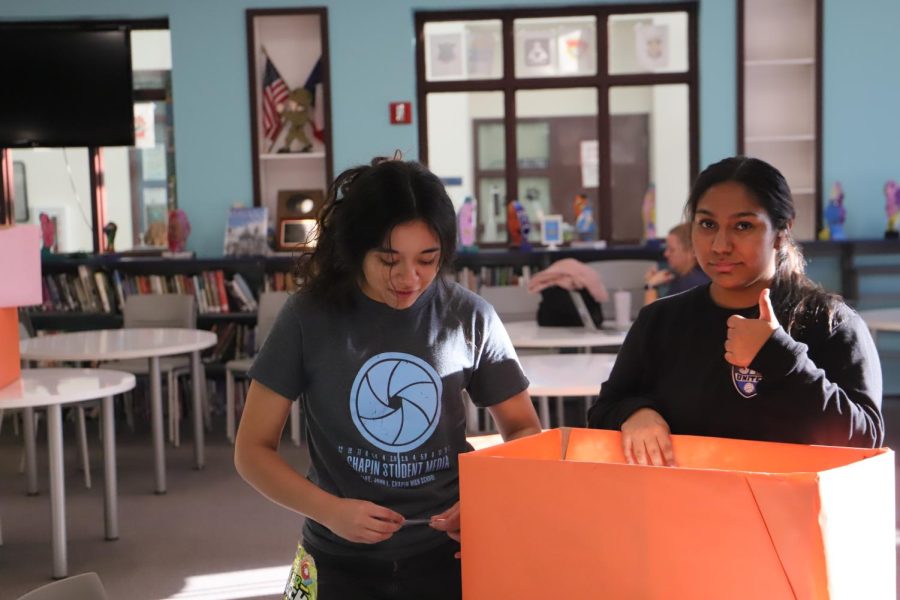 Maya Tinajero junior and Brissa Matamoros junior are both decorating a cardboard box for an E&E stuco meeting.