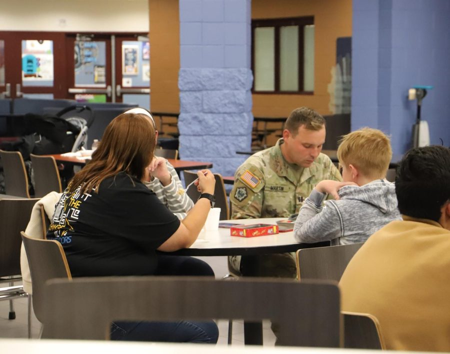 Bonnie Logsdon converses with a military family at an after school in the school cafeteria. Her office offers support and understanding to those who serve.