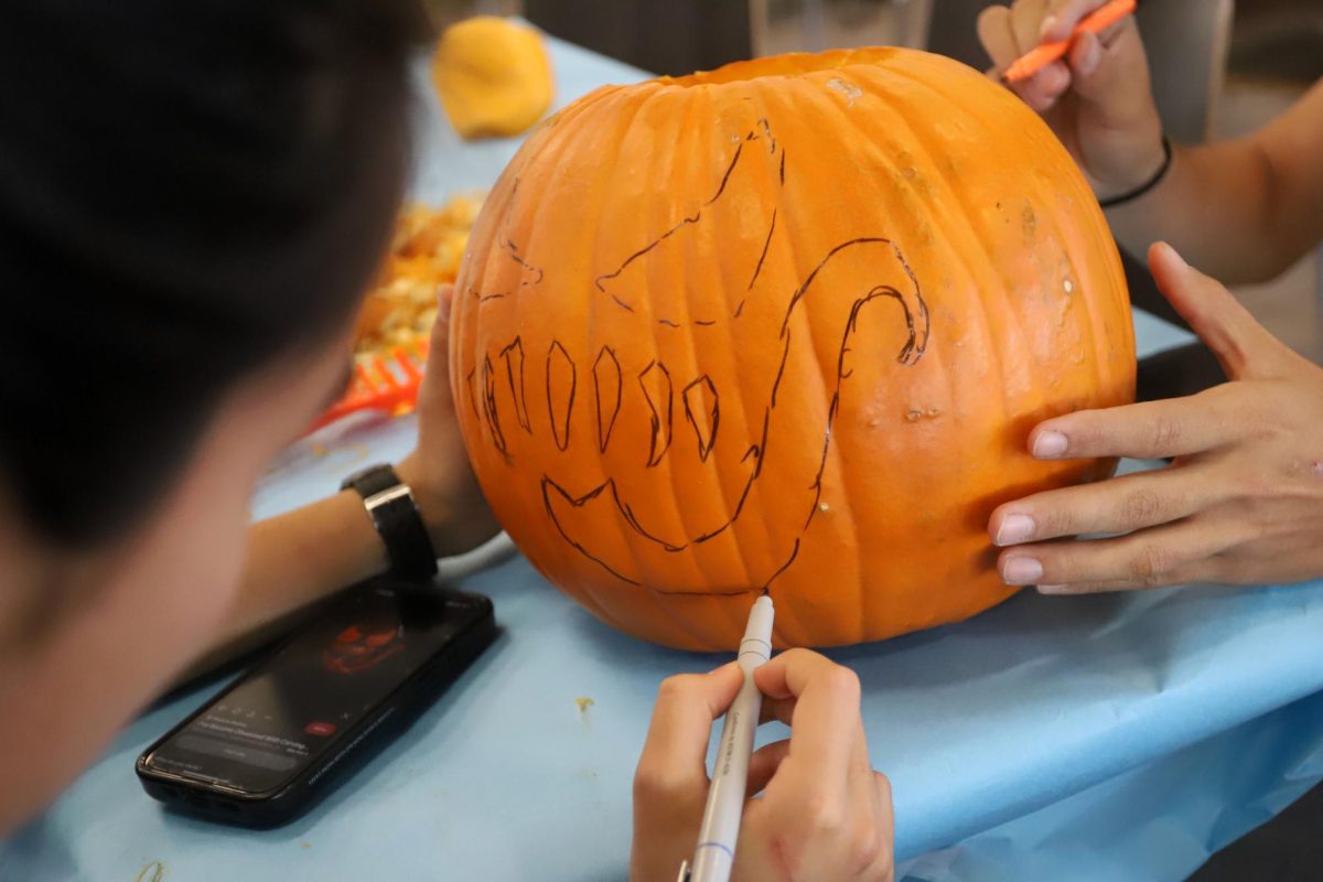 After choosing a design for their pumpkin, Seniors Patrick Whearley Sanchez and Ivanna Cho get to drawing. 