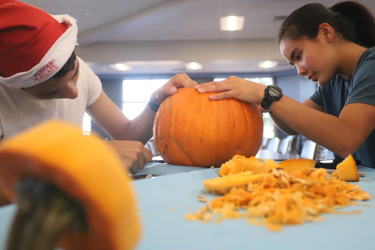 After clearing the pumpkin's insides, Seniors Patrick and Ivanna get to carving. Making sure to take their time, so as to not make any mistakes.