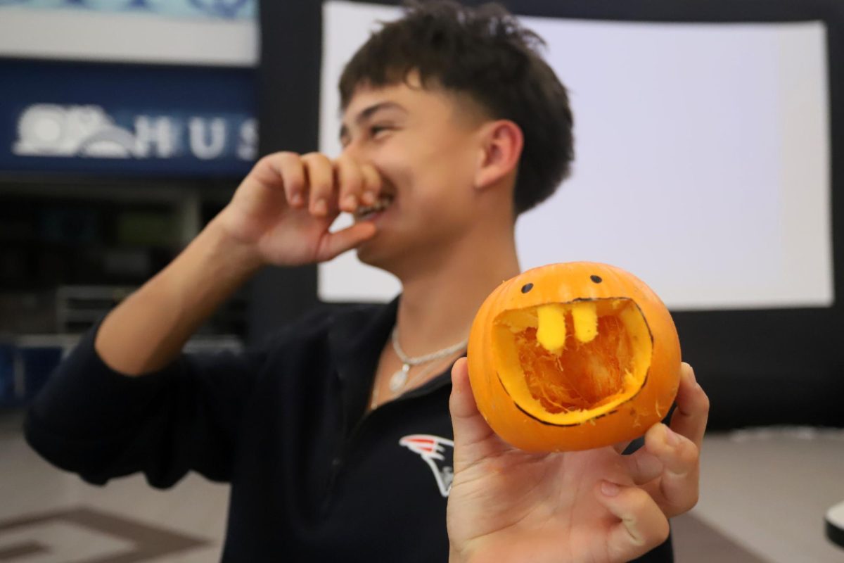 Laughing with friends, Senior Class Treasurer Mark Duggan shows off his silly little pumpkin.