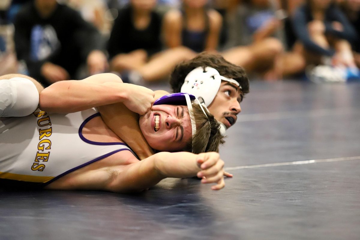 After successfully pinning his opponent, junior wrestler Sergio Vargas awaits coaches word for the next step. Sergio was able to secure the pin, and win his match. "My goals for the next competition is to have less compassion for others and be more aggressive," Sergio said. "I tend to take it easy on others. I should give everybody the same energy."