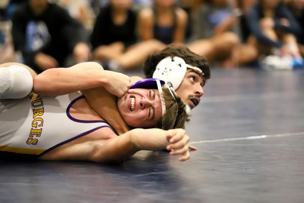 After successfully pinning his opponent, junior wrestler Sergio Vargas awaits coaches word for the next step. Sergio was able to secure the pin, and win his match. "My goals for the next competition is to have less compassion for others and be more aggressive," Sergio said. "I tend to take it easy on others. I should give everybody the same energy."