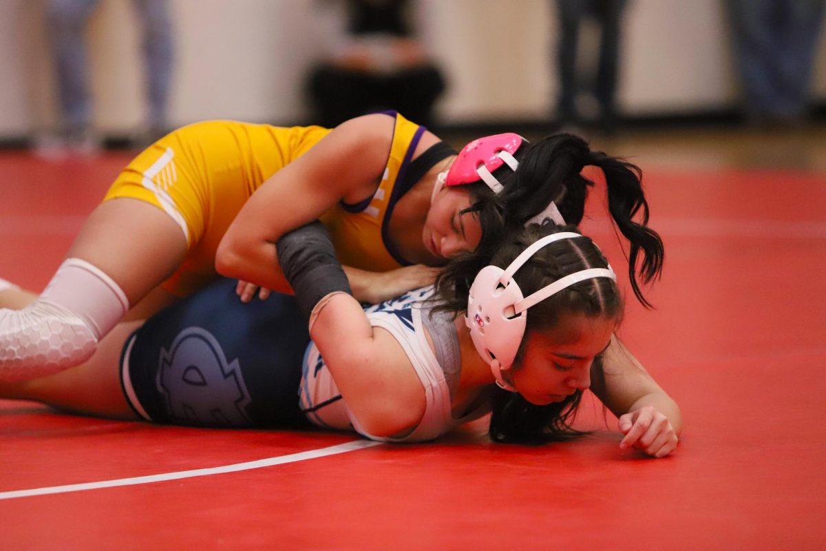 Battling against Burges High School, sophomore Haili Rodarte struggles to get out from under her opponent. 