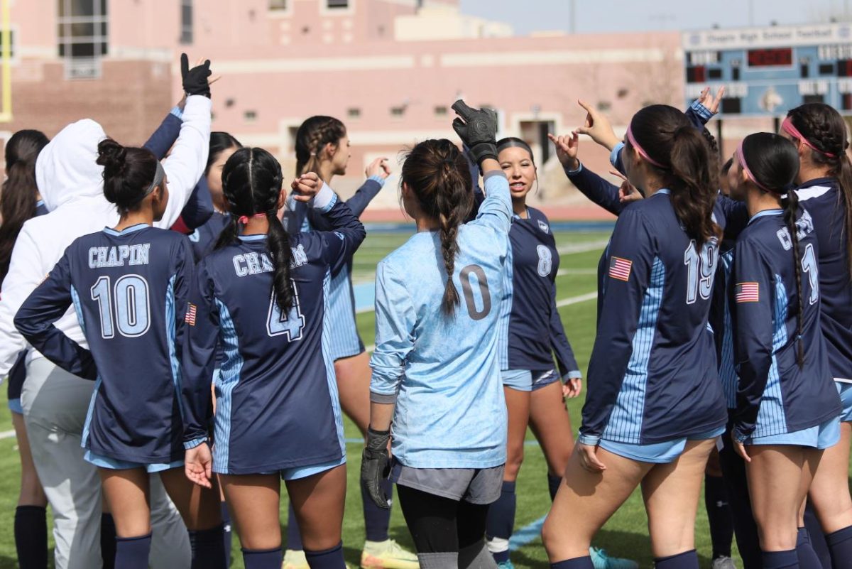 The Lady Huskies raise their hands in preparation for the remaining time of the game.
