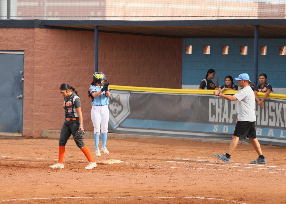 player hits hard and runs fast, she claps as she makes it to first looking at her coach