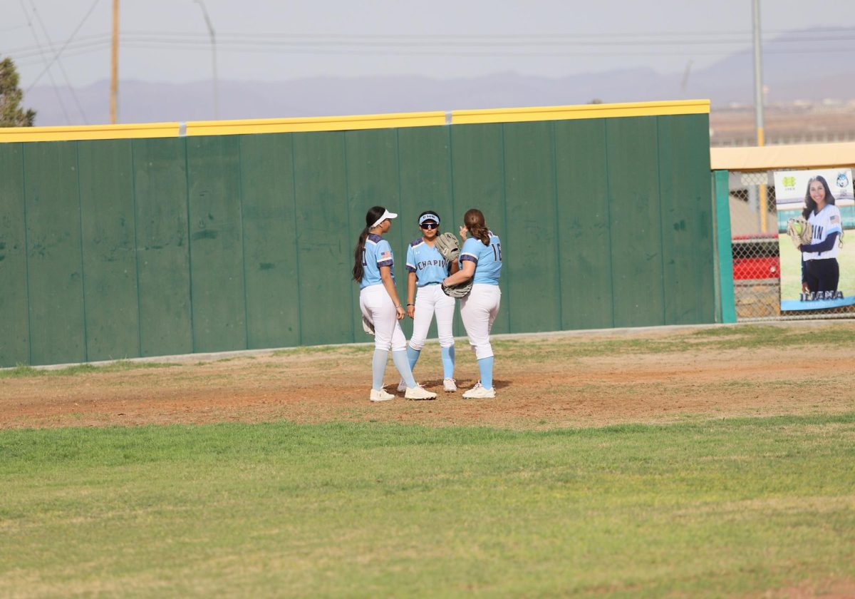 all girls in outfield huddle up while the other players on the field are taking their positions