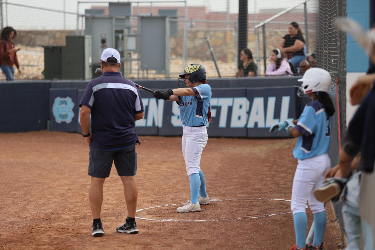 player practices hitting with the opposing team's pitcher while she waits for her turn to bat