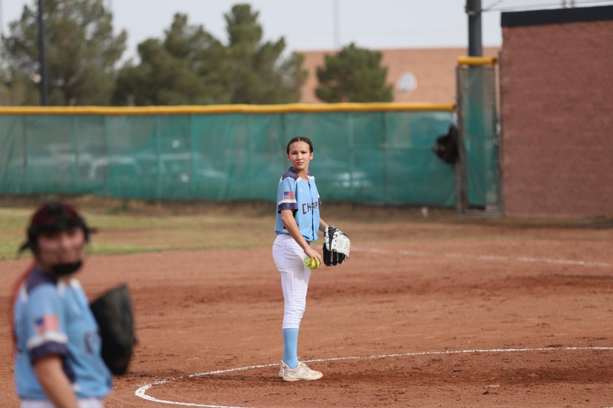Pitcher looks over to listen to her coaches advice before throwing a pitch