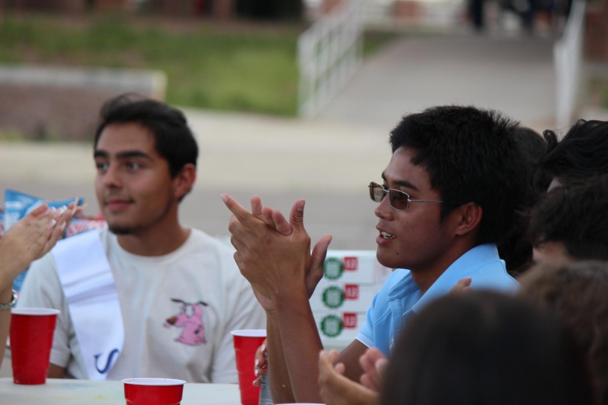 Student claps after hearing his coach give a speech.