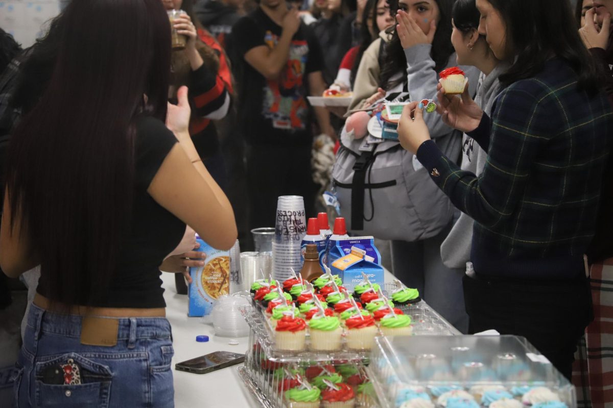 Success looks like a table full of cupcakes and a room full of happy people! The crowd gathering for a National Cupcake Day treat.