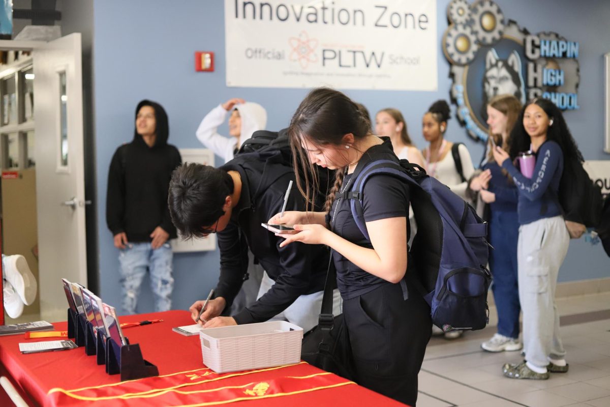 Come and try! Students signing up, "I liked doing sports so this interested me" said the one on the right that is signing up at the table.