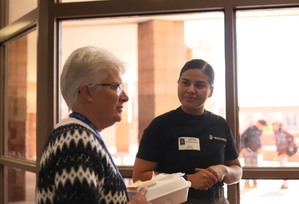 Coming out of the lunch room miss Sherman stops to talk with army visitor appreciating their work. 
"Thank you" said miss Sherman.