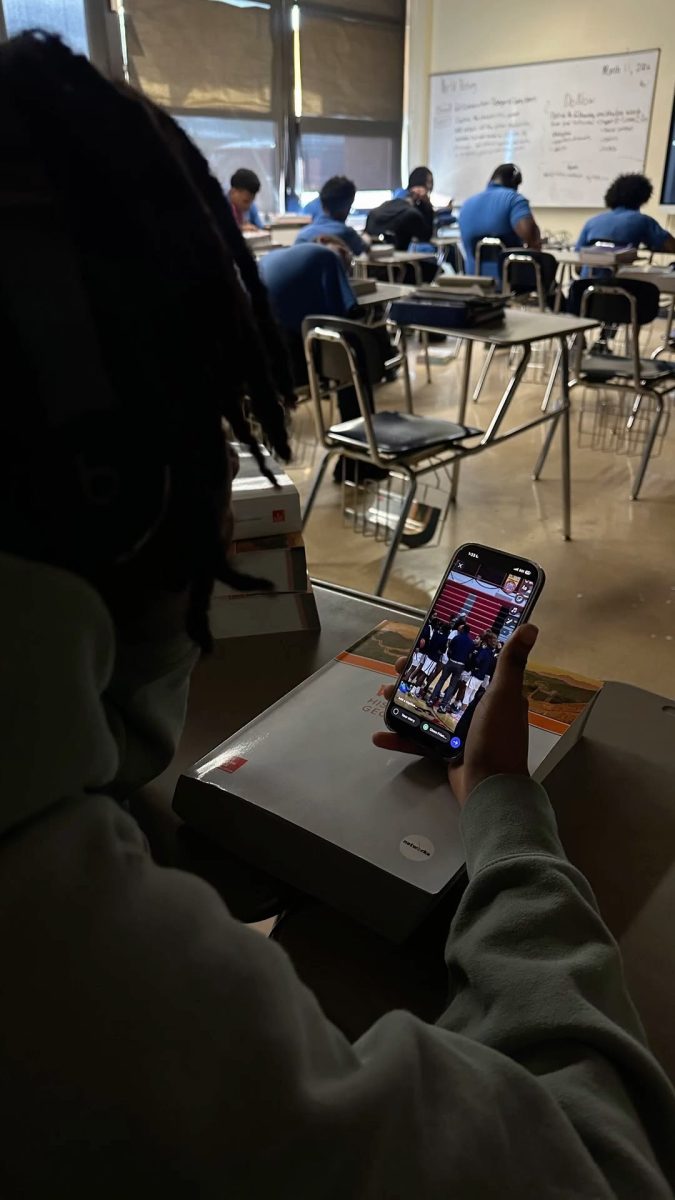 Despite school phone rules, some students still find ways to stay connected during class. A student scrolls through social media while classmates focus on their assignments.  
